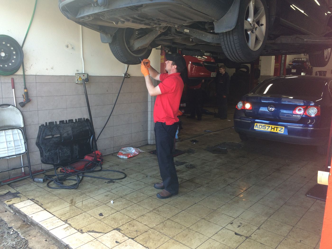 Technician inspecting the underside of a car