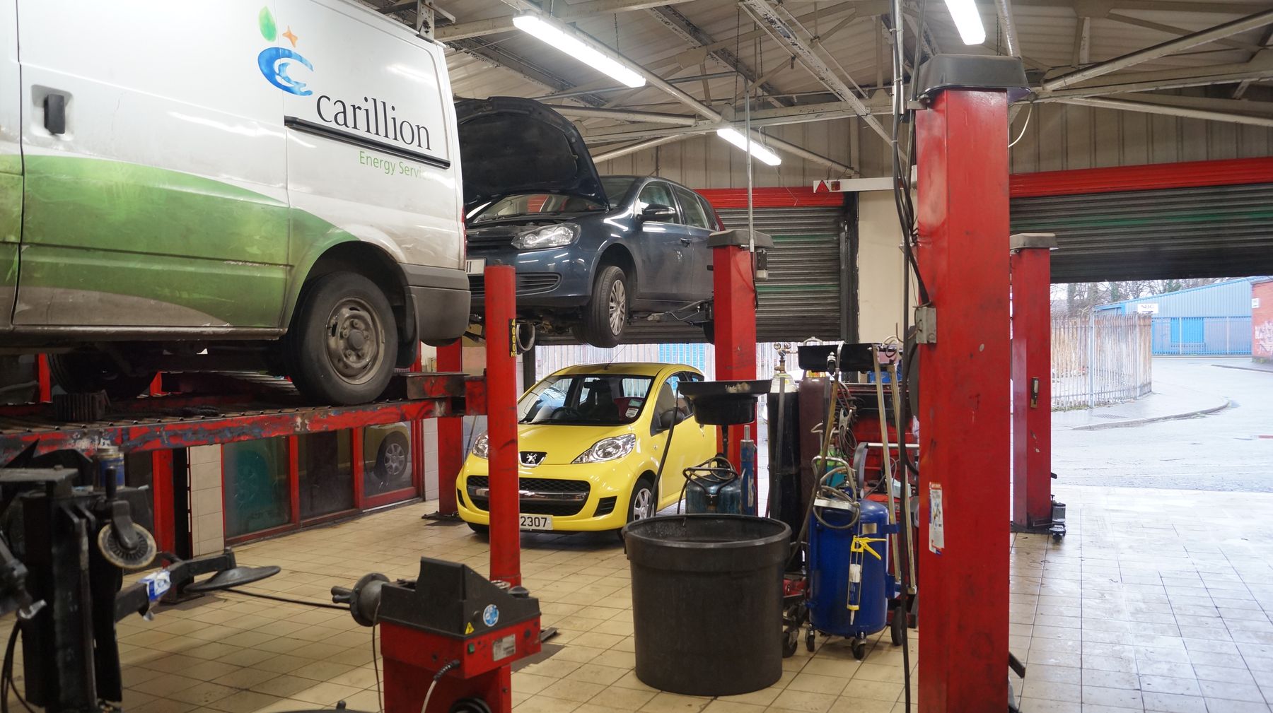 Workshop bays with vans and cars on ramps