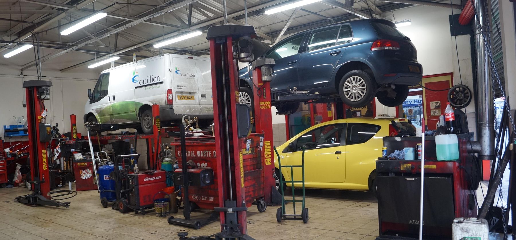 Inside the Sterrett's workshop: cars and a van on red Corgi ramps